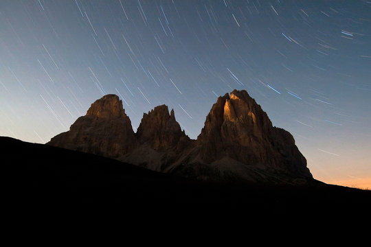 Startrail over the Sassolungo group in a moonless night in the Dolomites. Sella Pass. Fassa Valley. Trentino-Alto Adige. Italy. Europe