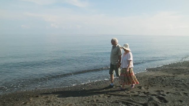 Incredibly touching pair of elderly people walking along the seaside