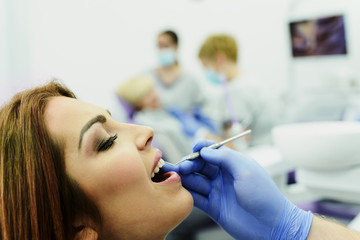 A young woman having a regular check up at dentists office