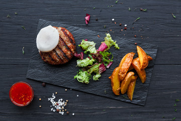 Grilled beef steak on dark wooden table background, top view