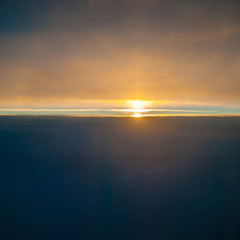 View of the sunrise and the clouds from within, out of the plane