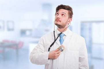 Doctor holding money and listening heart with stethoscope