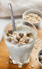 Yogurt with bran on a wooden board, vertical