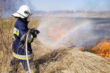 Naklejka premium Firefighter fights grass fires. Polish firefighter.