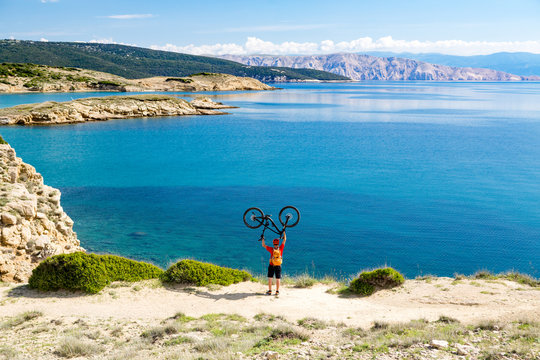 Mountain biker celebrating inspiring view at the sea