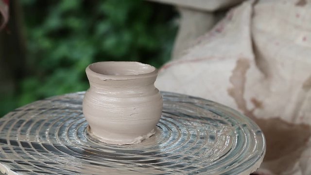 Man and woman makes a pot on pottery wheel. Hands of a potter and his apprentice. Man and woman hands. Woman is the pupil of a potter