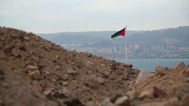 Flag of the Arab Revolt in Aqaba city, Hashemite Kingdom of Jordan, Red Sea, gulf of Aqaba and Eilat city in Israel at the distance. Two country in one video clip