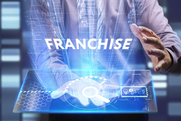Business, Technology, Internet and network concept. Young businessman working on a virtual screen of the future and sees the inscription: Franchise