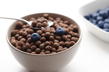 Bowl of cocoa cereals on white background close up