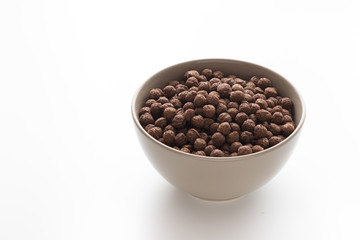 Bowl of cocoa cereals on white background