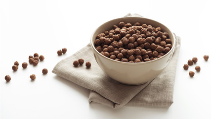 Bowl of cocoa cereals on white background