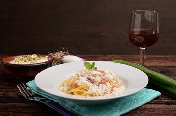 Dish of pasta noodles with cottage cheese bacon and onion shallot
