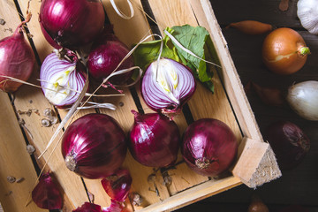 Freshly harvested red onion bulbs in wooden farmers box