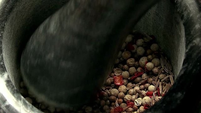Grinding of spices in a mortar. Mixing Spices