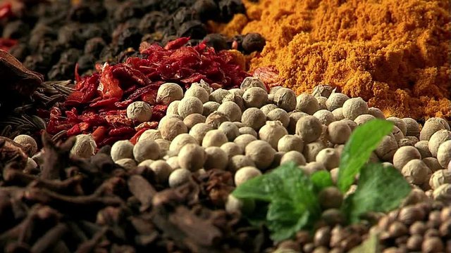 Peas of white pepper fall on spices. Mixing spices. Macro