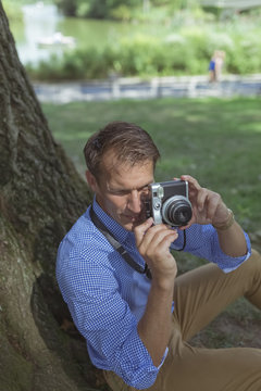 Man taking pictures with camera in a park