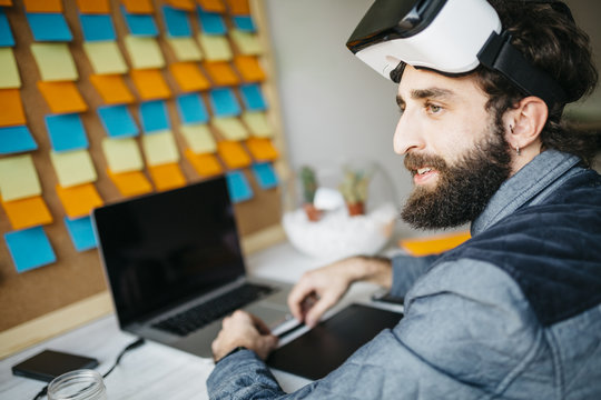 Man with Virtual Reality Glasses working on new project in his office
