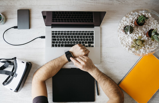 Man using smartwatch at desk, top view