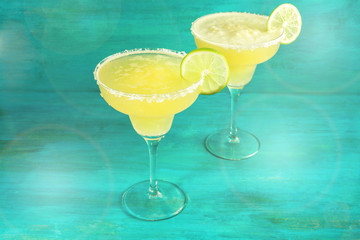 Lemon Margarita cocktails on vibrant teal with copyspace