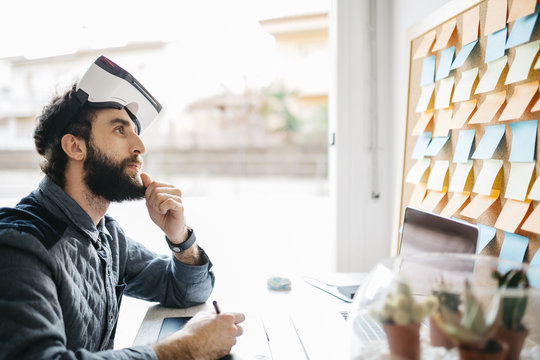 Man with Virtual Reality Glasses working on new project in his office