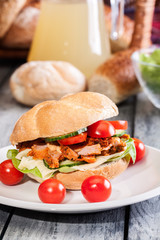 Fried chicken meat with cheese and vegetables in bun