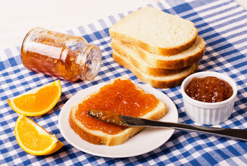 Jar of orange jam with bread