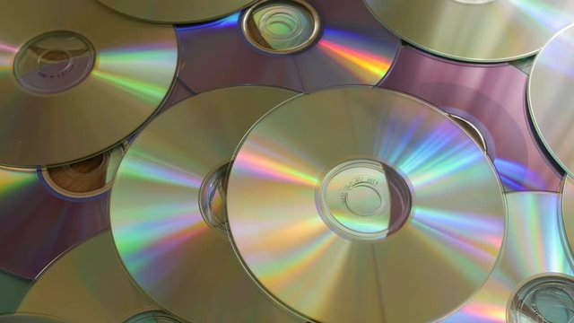 Optical Discs falling onto big pile of DVDs or CDs.