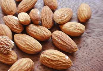 Close up almonds on wooden table, background.