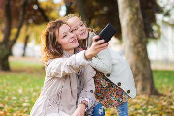 Girl playing with her mother in autumn park