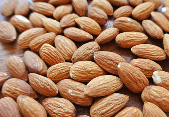 Almonds on wooden table, background.