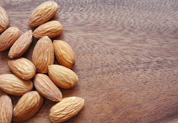 Almonds on wooden table, background with copy space.
