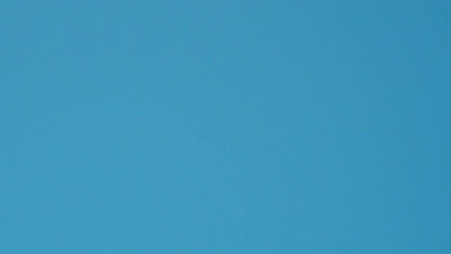 Slow motion looped video of big passenger airplane passes from top to bottom over head flying very low just before landing at bright and clean sunny day.