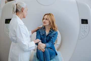Pleasant friendly doctor putting her hand on the patients shoulder