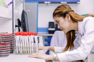 Young Asian researcher looking at the flask in the science laboratory