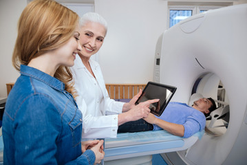 Nice delighted doctor holding a tablet