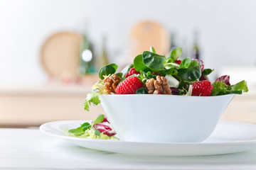 Green vegetarian salad with raspberry and walnut .