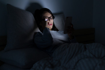 Obraz premium Woman feeling tired when using mobile phone at night