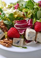 Green salad with blue cheese , raspberry and nuts