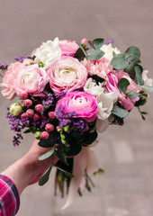 Delicate wedding bouquet of ranunculus flower, freesia and eucalyptus leaves in hand