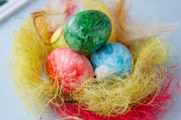 Colored easter eggs on vivid nest over bright and airy background.