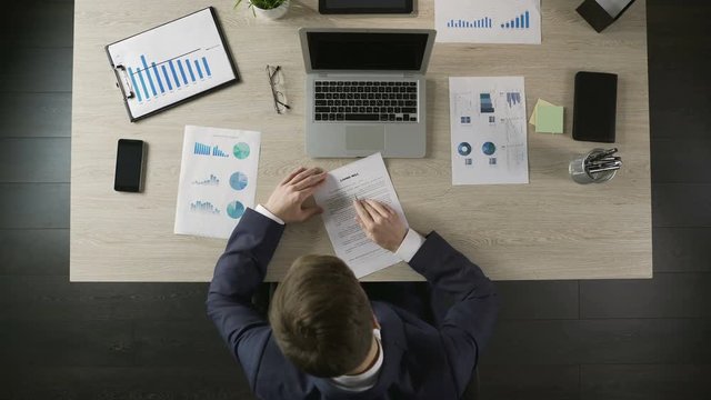 Rich man signing living will document, leaving company to business partner