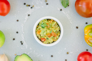 Traditional mexican avocado - vegetarian dip surrounded by its ingredients.