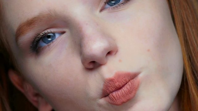 Close-up of a young cute red haired teen girl making funny faces 