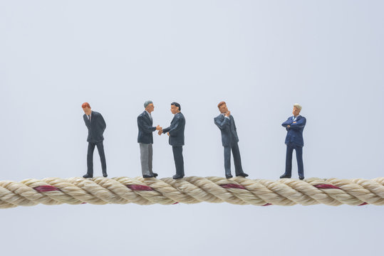 business miniature people standing on a rope - Powered by Adobe