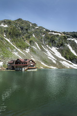 Vertical shot of beautiful, secluded cabin on the glacier lake  Balea, Romania