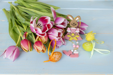 tulips flowers and easter eggs on a blue wooden background