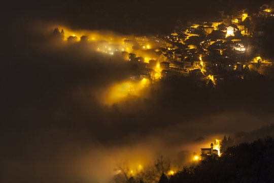 Molina of Palanzo village on Comolake by nigth surrounded by the fog, from Monte Boletto, Province of Como, Lombardy, Italy