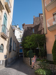 Portrait of beautiful girl posing in garden at street of Sorrento, Italy