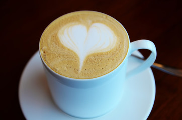 A cup of coffee with a heart pattern.