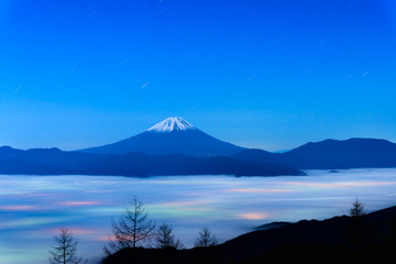 Fototapeta premium 雲海に浮かぶ富士山と雲に透ける街の灯り